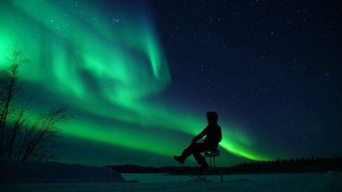 Man standing on snow against sky at night