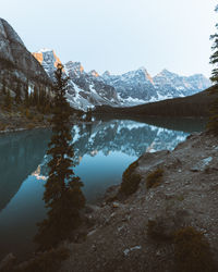 Scenic view of lake by snowcapped mountains against sky