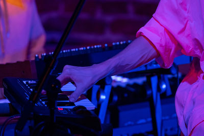 Midsection of man playing piano at music concert