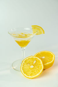 Yellow drink on glass against white background