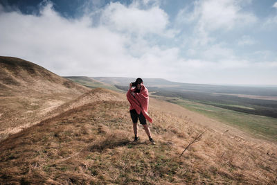 Man standing on landscape against sky