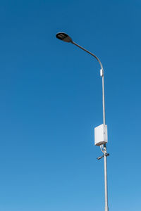 Low angle view of street light against blue sky