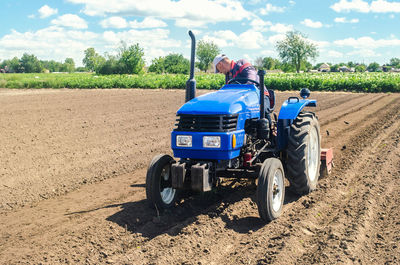 Farmer on a tractor loosens the soil with milling equipment. loosening surface, land cultivation.