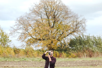 Rear view of woman standing on field