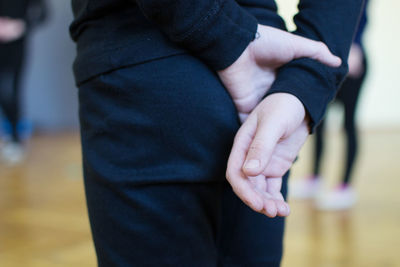 Midsection of man man with hands behind back