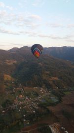 Hot air balloon flying over landscape against sky