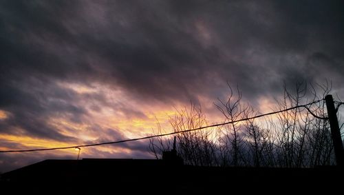 Silhouette of tree against cloudy sky