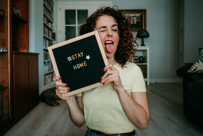 Woman holding slate with stay home text