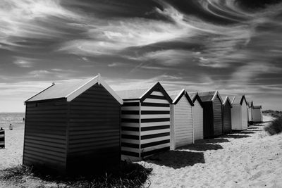 Residential buildings on beach against sky