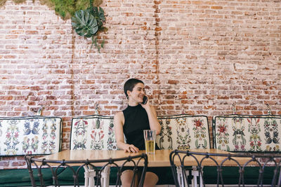 Woman standing against brick wall