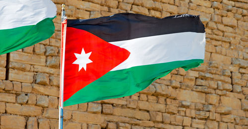 Low angle view of flag against brick wall