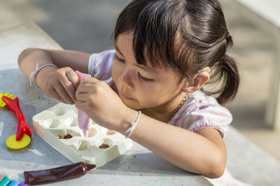 Close-up of cute girl with clay