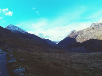 Scenic view of mountains against blue sky