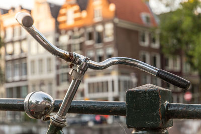 Close-up of bicycle on street against buildings in city