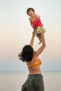 Mother playing with daughter at beach