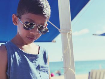Portrait of boy wearing sunglasses while standing at beach