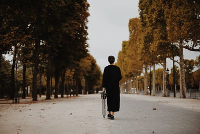 Rear view of man walking on street in city