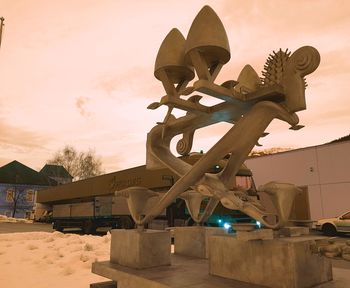 Low angle view of sculpture on building during sunset