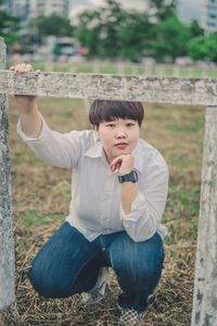 Portrait of young man sitting on field