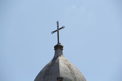 Low angle view of weather vane against blue sky