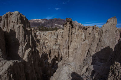 Low angle view of rock formations against blue sky