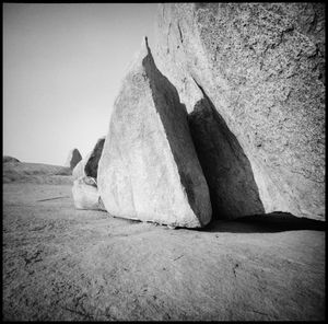 Rock formations on beach against clear sky