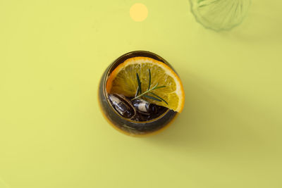 Directly above shot of lemon slice against yellow background