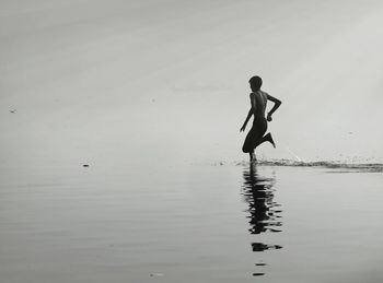 Full length of shirtless man running in sea