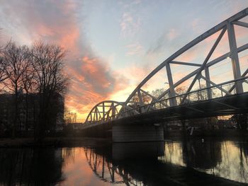 Bridge over river against sky during sunset