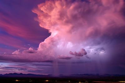 Lightning illuminates an isolated thunderstorm at sunset near san carlos, arizona.