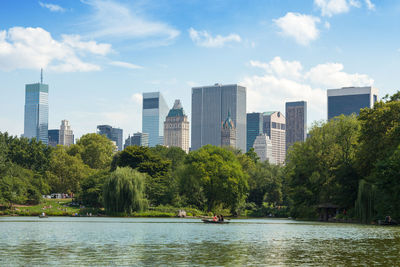 Scenic view of river by buildings against sky