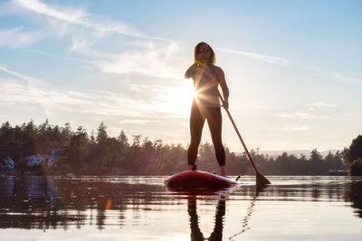 Full length of woman standing in lake against sky