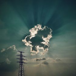Low angle view of silhouette electricity pylon against sky