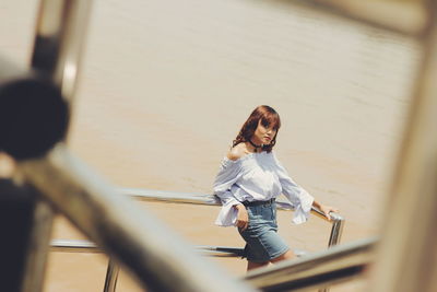 Young woman seen through railing