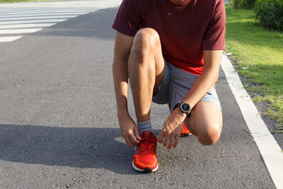 Close-up of sportsman.he tying sneakers on running shoes before practice. outdoor running concept.