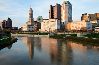 River by buildings against sky in city