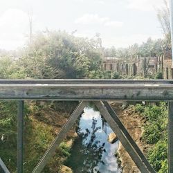 Bridge over river in city against sky