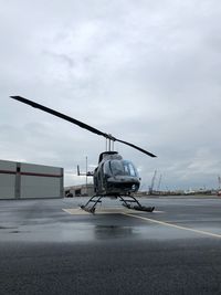 Airplane on airport runway against sky