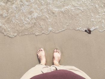 Low section of person standing on beach