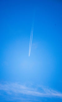 Low angle view of vapor trail against blue sky