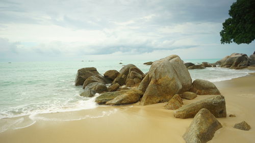 Rocks on beach against sky 8n tanjung pesona