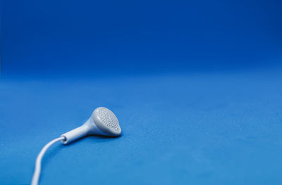 Close-up of electric fan against blue background