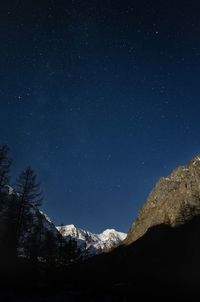 Low angle view of snowcapped mountains against sky at night