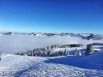 Scenic view of snow covered mountains against cloudy sky