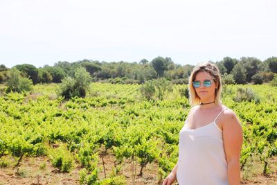 Portrait of woman standing against agricultural field on sunny day at beziers