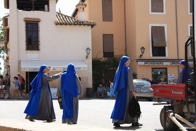 Nun walking on road against building