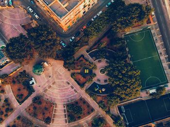 Aerial view of street and soccer field amidst buildings in city