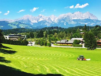 Scenic view of agricultural field and houses against sky