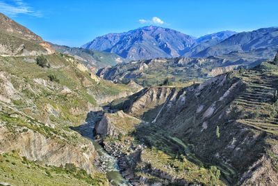 Scenic view of mountains against blue sky