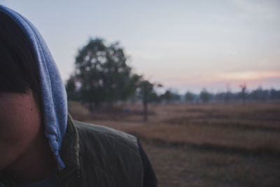 Rear view of man on field against sky during sunset